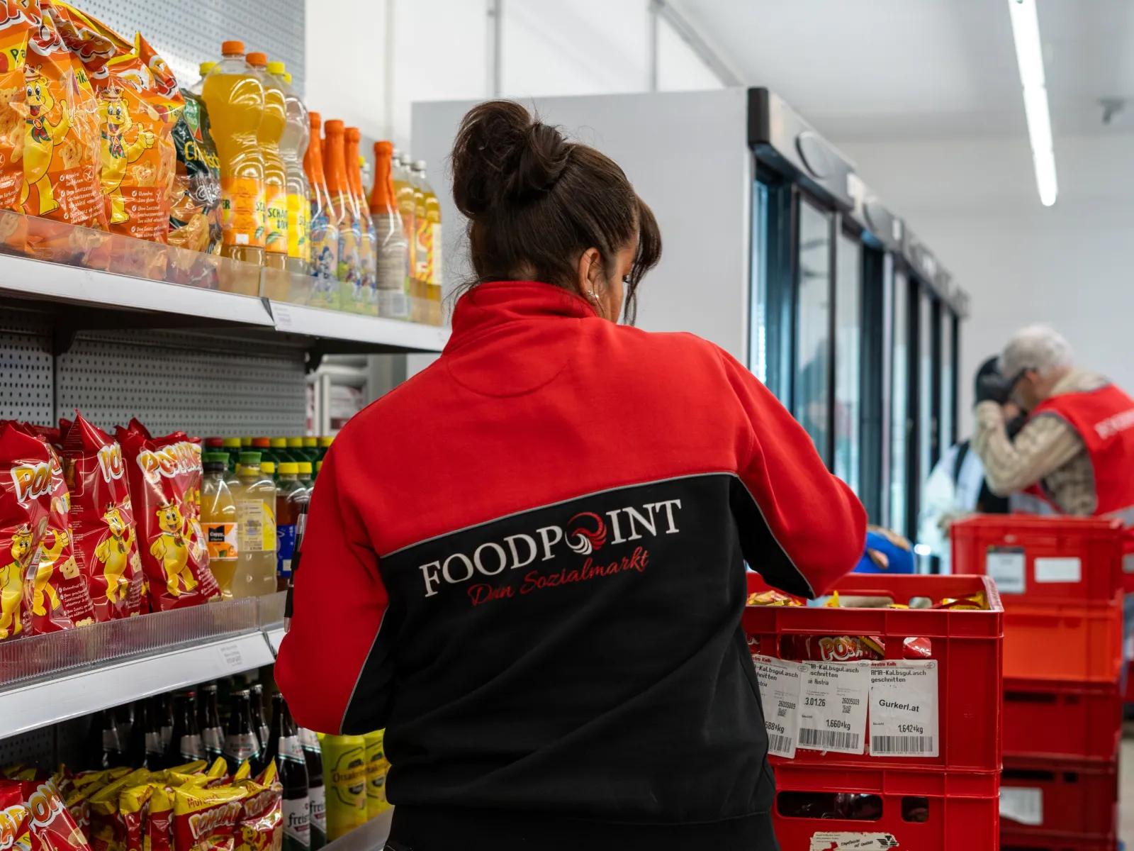 Mitarbeiterin in FOODPOINT-Jacke räumt Ware ein